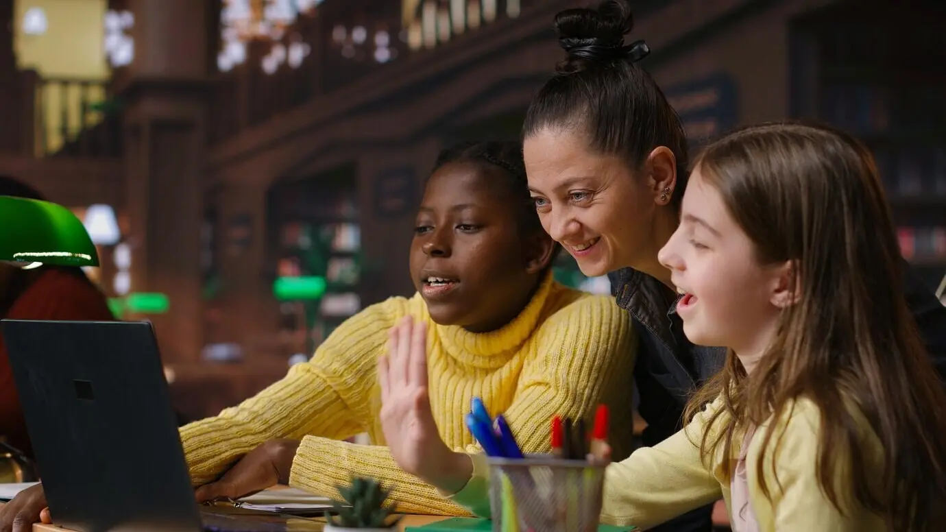 Multiethnische Lernende in der Bibliothek, die mit ihrem Mentor am Distanzlernen teilnehmen.
